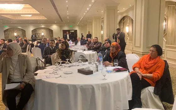 Participants at a round table facing the speaker